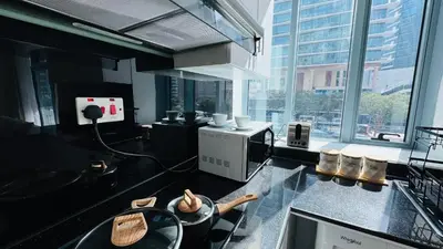 a kitchen with a counter with a sink and a microwave at 1 Bedroom with Balcony - Near Metro - Fast Wi-Fi in Dubai