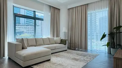 a living room with a couch and large windows at 1 Bedroom with Balcony - Near Metro - Fast Wi-Fi in Dubai