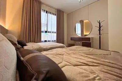 a bedroom with two beds and a mirror at Elegant 2BR Apartment with Huge Terrace, Dubai Land in Dubai