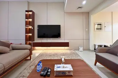 a living room with a couch and a tv at Elegant 2BR Apartment with Huge Terrace, Dubai Land in Dubai