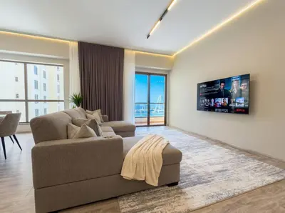 a living room with a couch and a tv at Stunning Sea View - 2-BR - 2 min Walk to Beach in Dubai