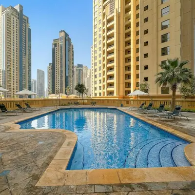 a swimming pool in the middle of a city with tall buildings at Stunning Sea View - 2-BR - 2 min Walk to Beach in Dubai