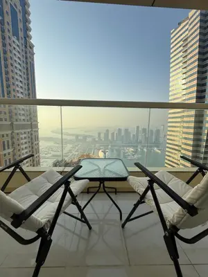 a balcony with two chairs and a table on a building at Palm Sea View - Dubai Marina- 2 Bedrooms in Dubai