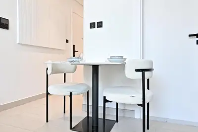 a kitchen with a table and two stools at Binghatti House JVC - Parking, Balcony, Gym & Pool in Dubai