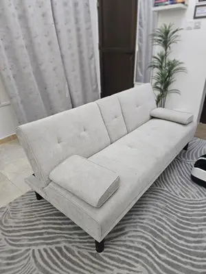 a white couch sitting in a living room at Elegant Grey Studio Room with Free Parking and Gaming in Dubai
