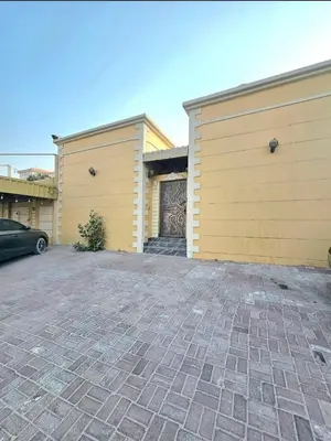 a house with two garage doors and a driveway at Elegant Grey Studio Room with Free Parking and Gaming in Dubai