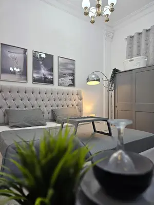 a living room with a bed and a table at Elegant Grey Studio Room with Free Parking and Gaming in Dubai