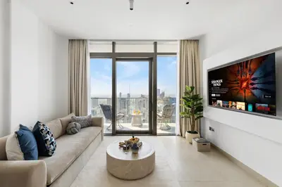a living room with a couch and a tv at Deluxe Marina Gate Suite with Sea and Ain Dubai View in Dubai