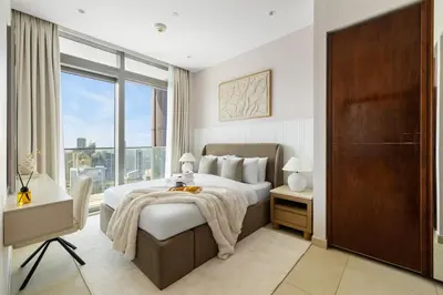 a bedroom with a large bed and a large window at Deluxe Marina Gate Suite with Sea and Ain Dubai View in Dubai