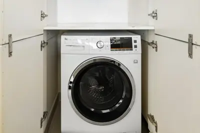 a washer and dryer in a white laundry room at Deluxe Marina Gate Suite with Sea and Ain Dubai View in Dubai
