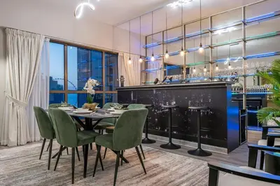 a dining room with a table and chairs and a bar at Boutique 3BR in JBR Upgraded by UDH in Dubai