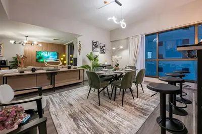 a dining room and living room with a table and chairs at Boutique 3BR in JBR Upgraded by UDH in Dubai