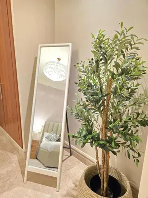 a tree in a pot next to a mirror at Fairmont North Residences Palm Jumeirah in Dubai