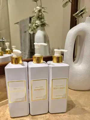 two white and gold bottles of soap on a counter at Fairmont North Residences Palm Jumeirah in Dubai
