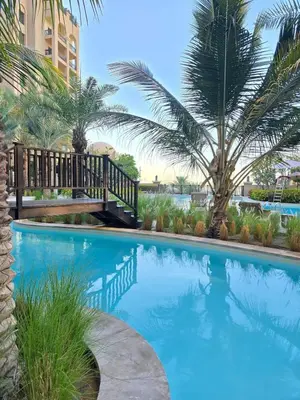 a swimming pool with a bridge and a palm tree at Fairmont North Residences Palm Jumeirah in Dubai