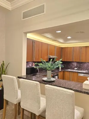 a kitchen with a table with chairs and a counter top at Fairmont North Residences Palm Jumeirah in Dubai