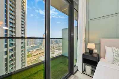 a bedroom with a bed and a large window at DAMAC Maison Aykon City Dubai in Dubai