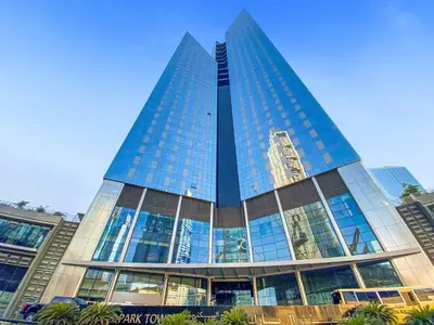 a tall building with glass windows in a city at Silkhaus Modern Studio in Central Park Tower DIFC in Dubai