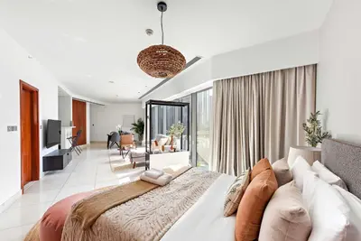 a bedroom with a large bed and a living room at Silkhaus Modern Studio in Central Park Tower DIFC in Dubai