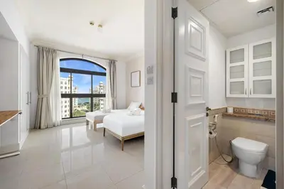 a white bedroom with a bed and a window at Renovated 2 Br in Golden Mile 5 Near Nakheel Mall in Dubai