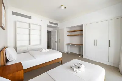 two beds in a room with white cabinets at Renovated 2 Br in Golden Mile 5 Near Nakheel Mall in Dubai