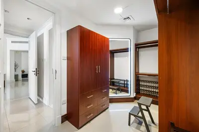 a room with a large wooden cabinet and a mirror at Renovated 2 Br in Golden Mile 5 Near Nakheel Mall in Dubai