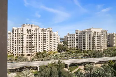 two large white buildings with a bridge in front at Renovated 2 Br in Golden Mile 5 Near Nakheel Mall in Dubai