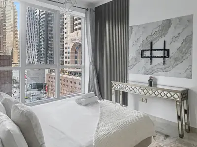 a bedroom with a white bed and a large window at Cozy 2BR l Marina l Steps to Beach l Balcony l Pool in Dubai