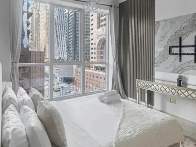 a bedroom with a large window and a large white bed at Cozy 2BR l Marina l Steps to Beach l Balcony l Pool in Dubai