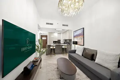 a living room with a couch and a large screen at FIRST CLASS 1BR Luxury Comfort Prime Location in Dubai