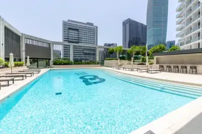 a large swimming pool with chairs and a building at FIRST CLASS 1BR Luxury Comfort Prime Location in Dubai