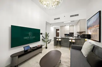 a living room with a couch and a tv on a wall at FIRST CLASS 1BR Luxury Comfort Prime Location in Dubai