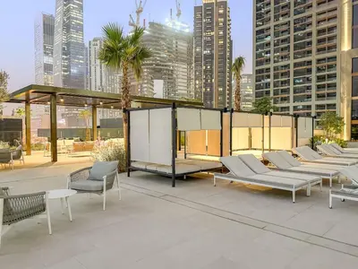 a group of chairs and tables on a patio in a city at FIRST CLASS Studio Relaxing Canal View in Dubai