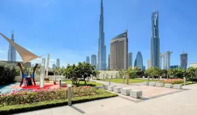 a park in a city with tall buildings at Luxury 2 Bedroom Apartment In Downtown in Dubai