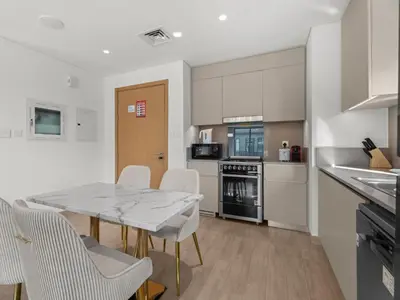 a kitchen and dining room with a table and chairs at The Royal Suite 1 BDR in Sunset-02 in Dubai