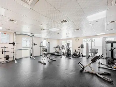 a gym with several treadmills and cardio machines at Modern Comfort City Studio In Al Manara 04 in Dubai