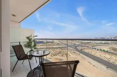 a balcony with a table and chairs and a view of the beach at Stylish Studio with Balcony in Carson Tower, DAMAC Hills in Dubai