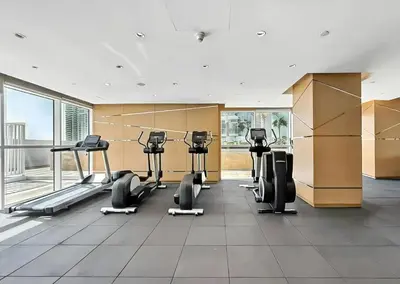 a gym with treadmills and cardio equipment in a building at Stylish Studio with Balcony in Carson Tower, DAMAC Hills in Dubai
