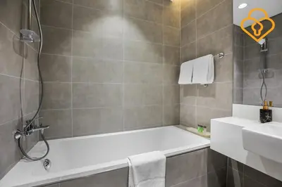 a bathroom with a bath tub and a sink at Beautiful Large 1BR Apt in District 1, MBR Minutes to Downtown in Dubai