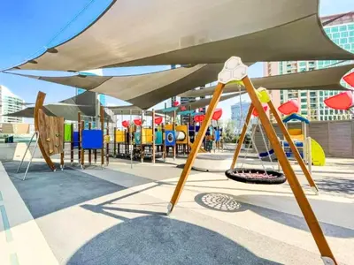 a playground with a large umbrella and chairs at Chic Getaway with Downtown View, Walk to Dubai Mall and Burj in Dubai