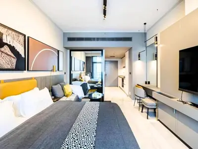 a bedroom with a large bed and a living room at Chic Getaway with Downtown View, Walk to Dubai Mall and Burj in Dubai