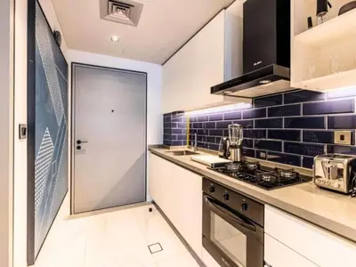 a kitchen with a stove top oven next to a door at Chic Getaway with Downtown View, Walk to Dubai Mall and Burj in Dubai