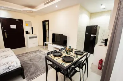 a living room with a table and chairs in a room at Fully Furnished Studio at City Tower al Barsha Near Mall of the Emirates in Dubai