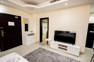 a living room with a large flat screen tv at Fully Furnished Studio at City Tower al Barsha Near Mall of the Emirates in Dubai