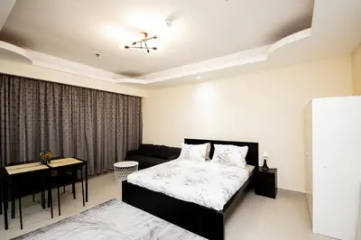 a bedroom with a bed and a couch and a table at Fully Furnished Studio at City Tower al Barsha Near Mall of the Emirates in Dubai
