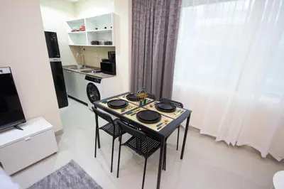 a dining room table with two chairs and a kitchen at Fully Furnished Studio at City Tower al Barsha Near Mall of the Emirates in Dubai