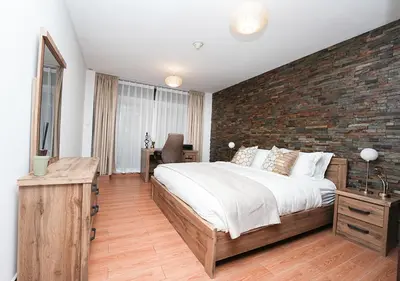 a bedroom with a large bed and a brick wall at Luxury Executive 1BR with Full Burj Khalifa View- Downtown in Dubai