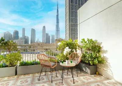 a balcony with chairs and a table with a view of a city at Luxury Executive 1BR with Full Burj Khalifa View- Downtown in Dubai