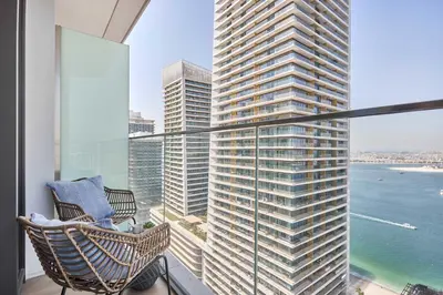 a balcony with a chair and a large building at Frank Porter - Palace Beach Residence in Dubai