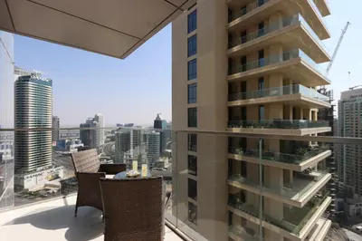 a balcony with chairs and a view of a city at Spacious 1BR with Open Views Boulevard Point Near Dubai Mall in Dubai